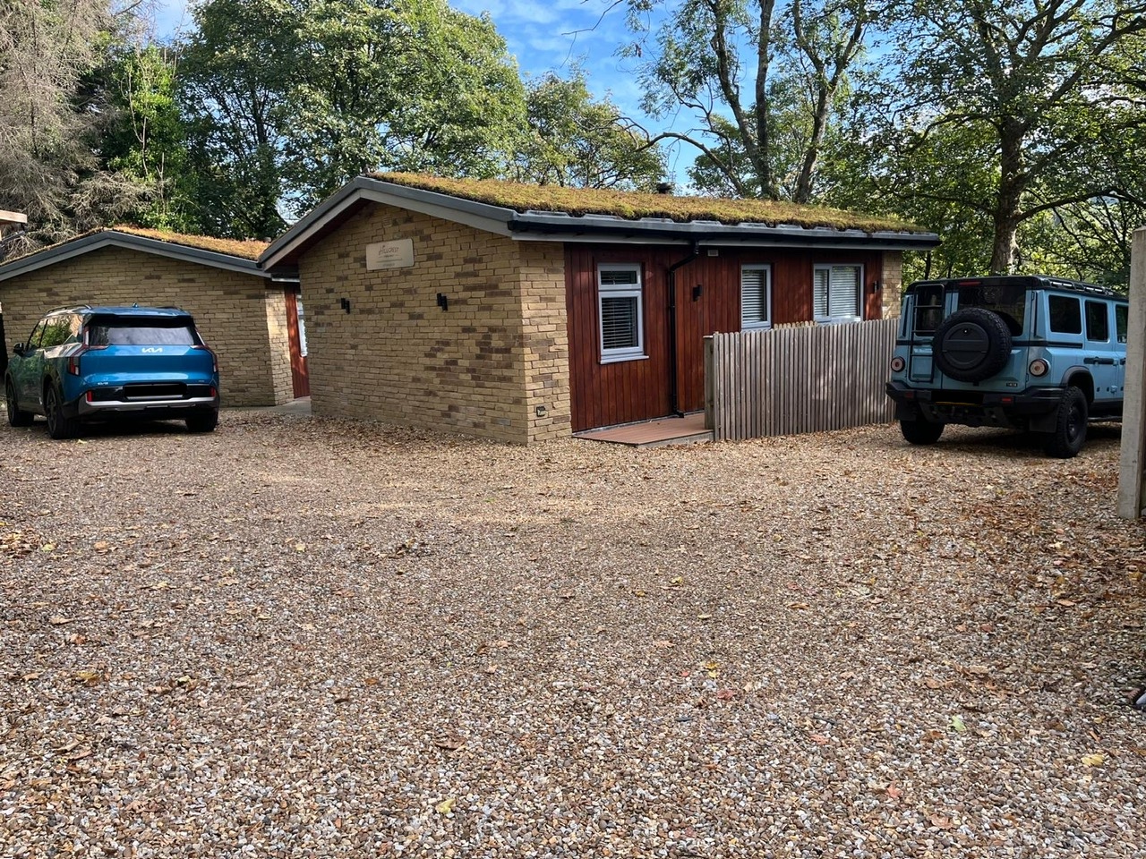 Cars parked outside Stepping Stones and Tree Tops Chalets at Hillcrest Holiday Homes, Uppermill, Saddleworth
